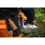 A person wearing orange protective chainsaw trousers holds an orange and white chainsaw at their side.