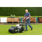 A man pushes a black Allett petrol cylinder mower across a manicured bowling green lined with benches.