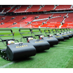 A row of black Allett cylinder mowers with gold branding stands lined up on the pitch at a football stadium.