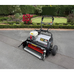 An Allett petrol cylinder mower parked on a driveway beside a landscaped garden bed with red flowers.