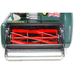 A close-up view of the red cutting cylinder blades and chrome rear roller of a green cylinder lawn mower.