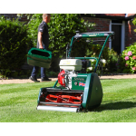 Kensington cylinder mower on a lawn with a man carrying a grass box behind