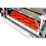 Close-up of a cylinder mower's red cutting reel alongside a white bristle brush bar.