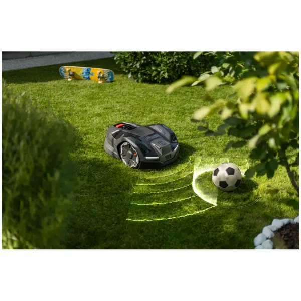 robotic mower cutting lawn near football and skateboard