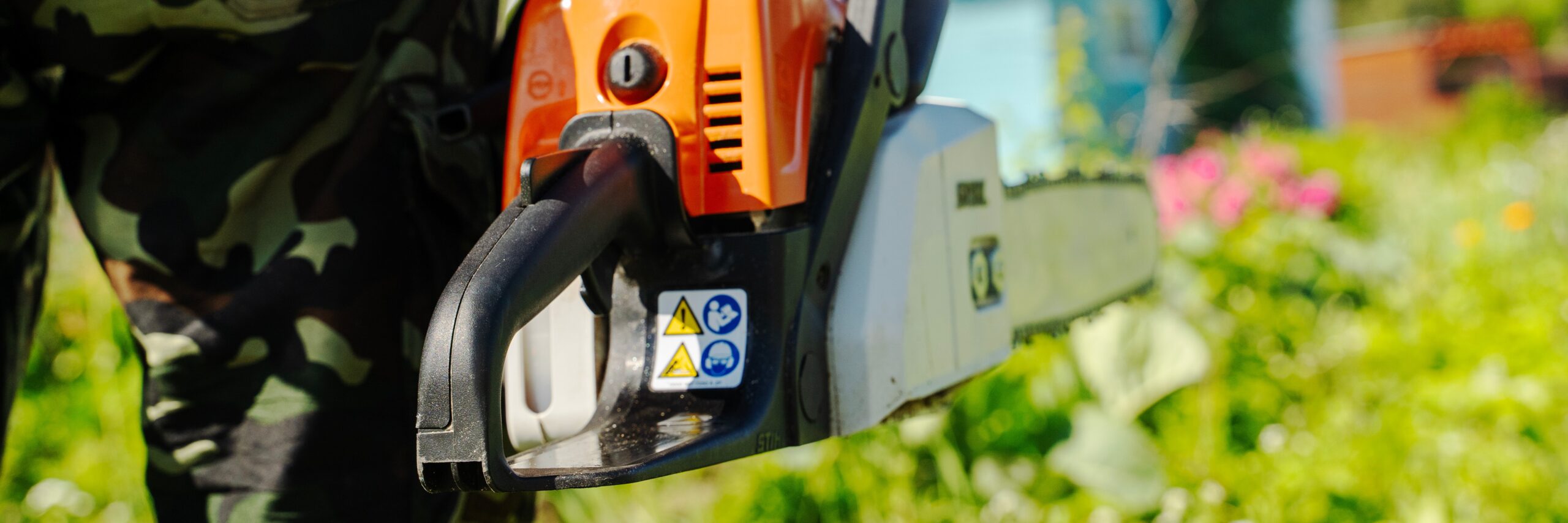 Outdoor chainsaw held by a person in camouflage gear