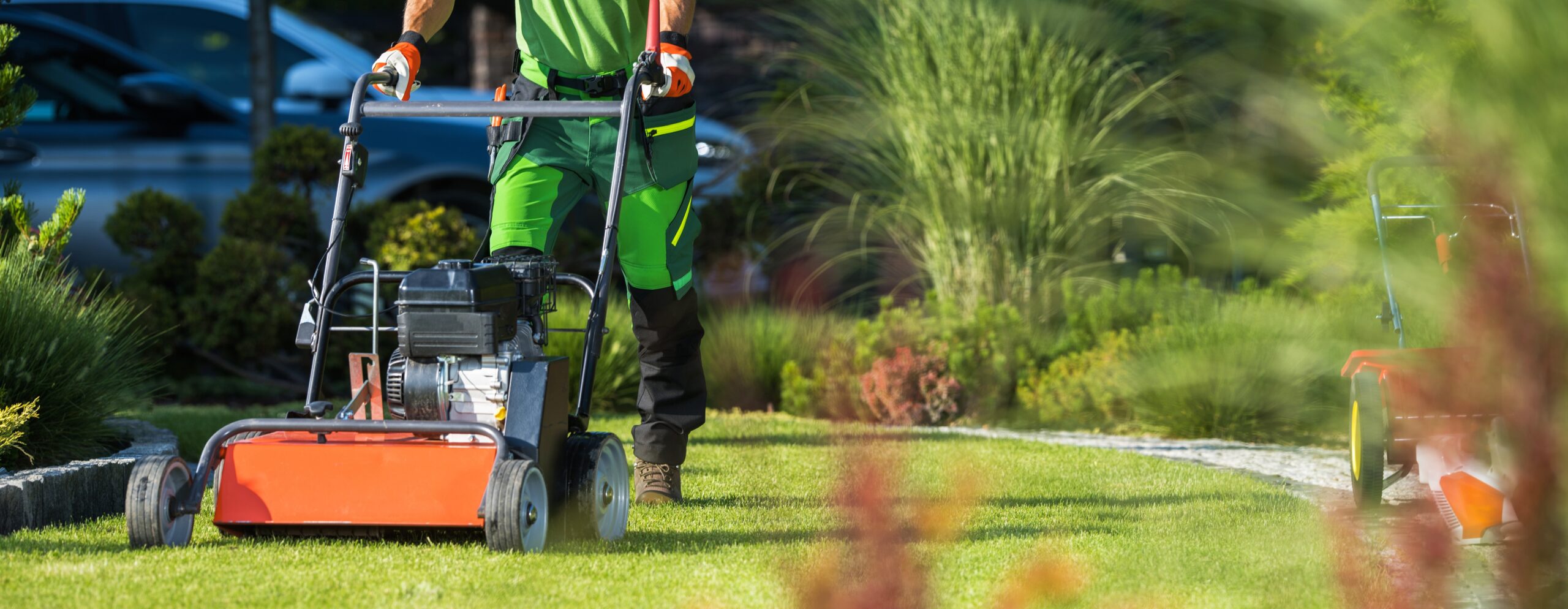 Landscaper with Scarifier Machine Taking Care of a Lawn.