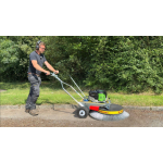 Person using a Westermann Moss Brush on tarmac