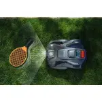 Robotic lawn mower operating on a grass lawn, viewed from above.